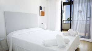 A modern hotel room with a large bed, a small bedside table, and a view of the balcony. - Casares Del Mar (Casares)