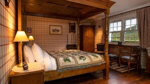 A traditional four-poster bed with a quilt, wooden nightstands, a lamp, and a chair. - The wooden floors, vintage furniture, and tartan accents create a comfy room (Inverness)