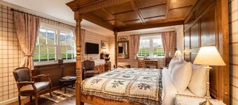 The wooden floors, vintage furniture, and tartan accents create a comfy room