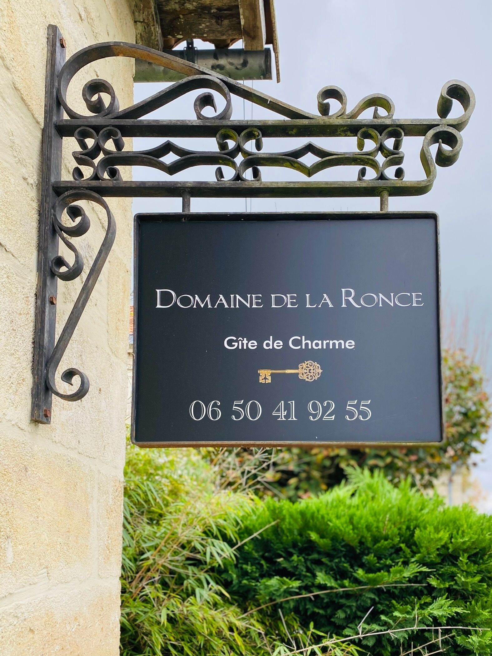 Schild für Domaine de la Ronce, ein Schloss mit Schlüsselsymbol, das auf einen möglichen historischen oder bedeutenden Ort hinweist.