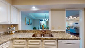 A kitchen with granite countertops, white cabinetry, and a dishwasher. - Large Golf Course Villa with Lots of Space for Everyone! (Hilton Head)