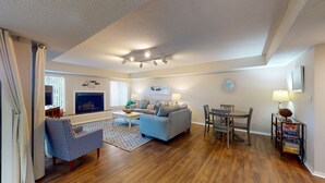 A spacious living room with a sofa, armchair, and dining table. - Large Golf Course Villa with Lots of Space for Everyone! (Hilton Head)