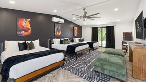 Una habitación de hotel moderna con dos camas, un escritorio y un ventanal grande.