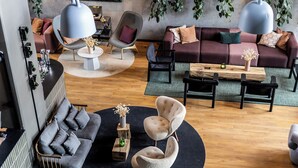 A modern living room with a grey sofa, two armchairs, a coffee table, and a wooden side table. - Peak 12 Design Hotel (Viborg)
