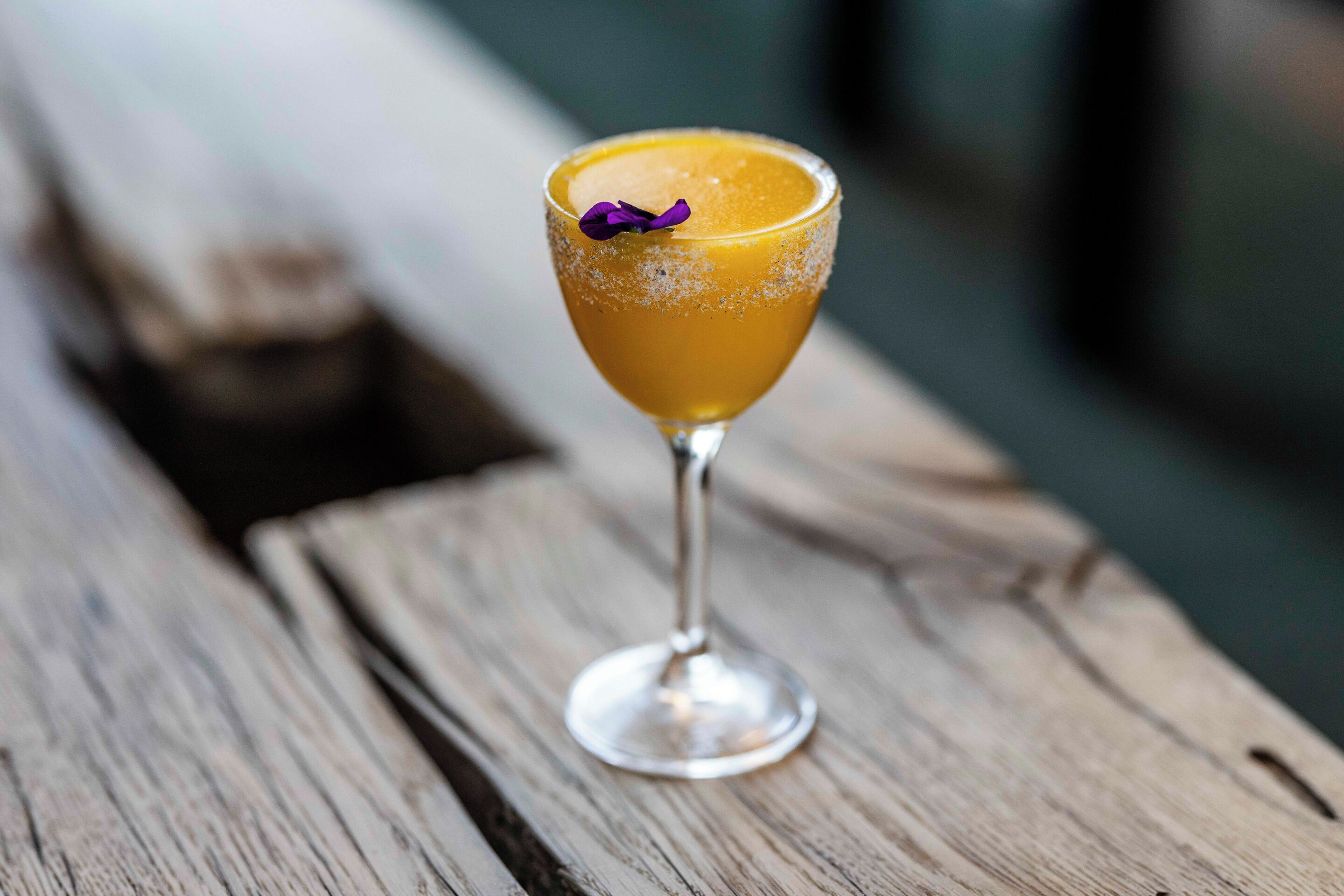 Un cocktail servi dans un verre, posé sur une surface en bois.