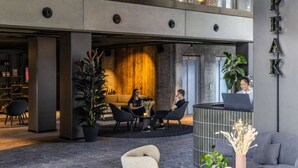 A modern lobby with a reception desk, seating area, and a large plant. - Peak 12 Design Hotel (Viborg)