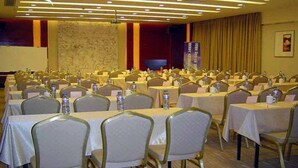 A conference room with multiple tables and chairs, equipped with water bottles and nameplates. - Dynasty Commercial Hotel (Zhongshan)