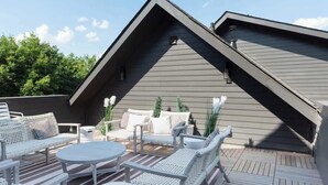An outdoor patio with white wicker furniture, a round table, and a grey building in the background. - Spacious 4BR, Rooftop Patio, Garage, Walk to Faves |  5 Mins to Nissan Stadium, Less than 10 Mins to Broadway, 24 Hr Hospitality, Great for Groups (Nashville)