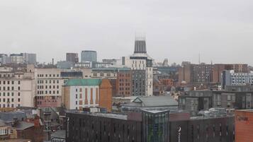 Un paisaje urbano con varios edificios, incluyendo un hotel destacado con una torre distintiva y un edificio moderno con fachada de vidrio.