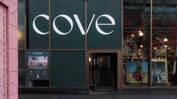 A storefront with a large 'cove' sign, a glass door entrance, and a poster advertising 'Paradise Street.'