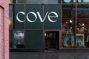 A storefront with a large 'cove' sign, a glass door entrance, and a poster advertising 'Paradise Street.'