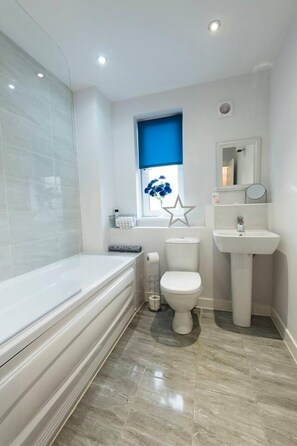A modern bathroom with a bathtub, toilet, and sink. - 1 bed Apartment Close to Football Grounds (Liverpool)