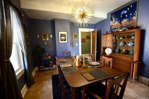 Dine in style with a beautifully set table for four, surrounded by artwork and a stunning chandelier.