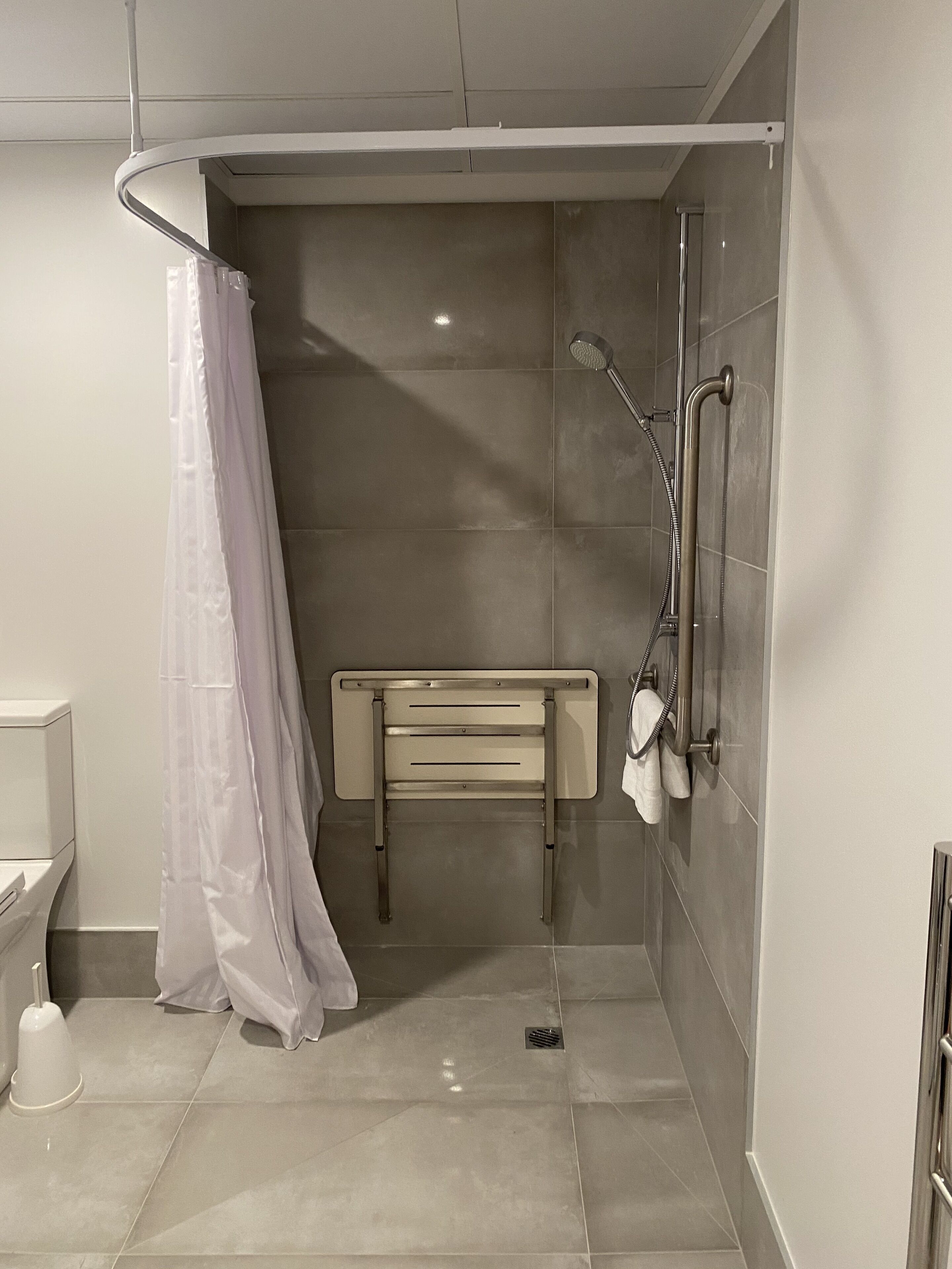 A modern bathroom with a shower, toilet, and vanity.