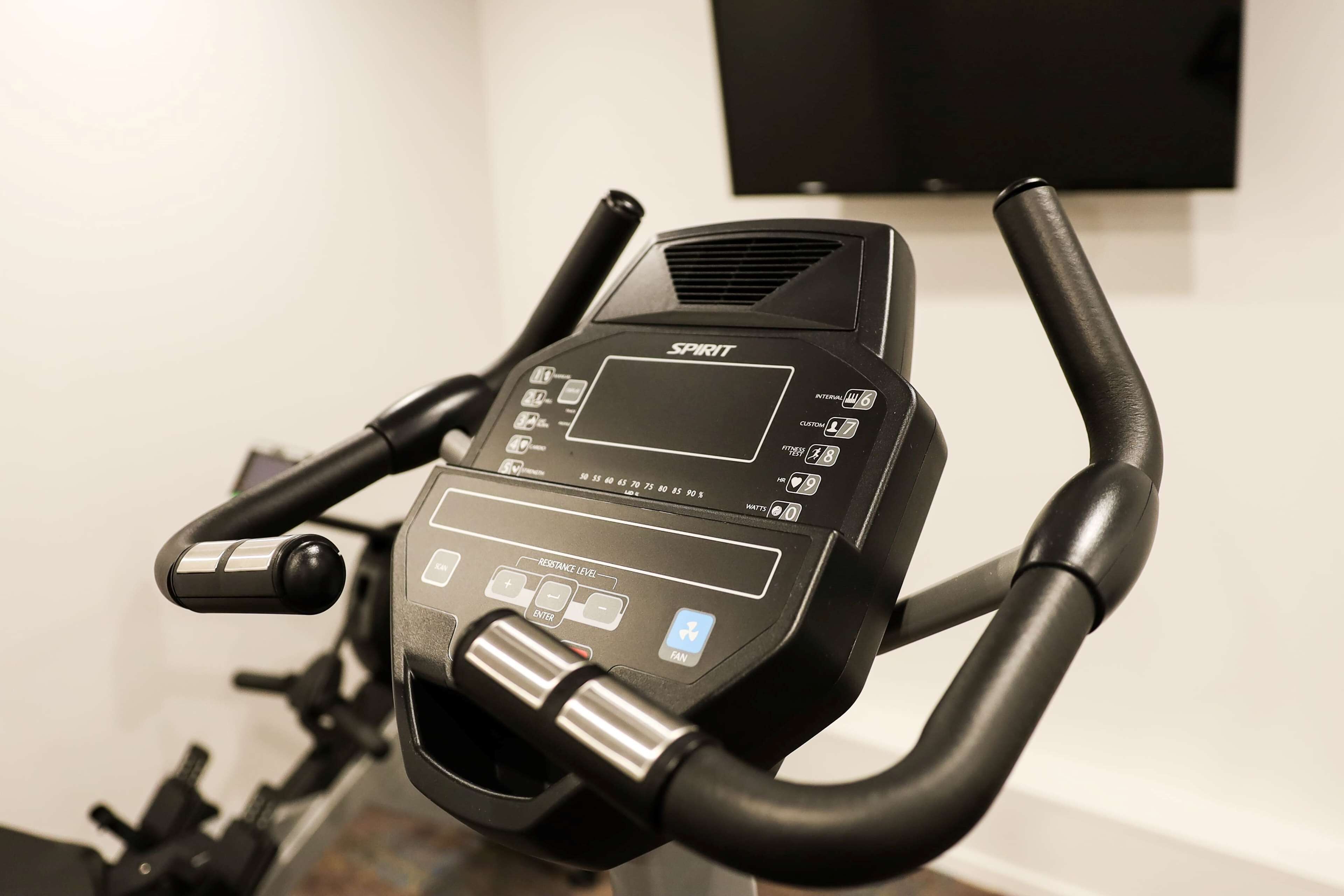 A stationary bike with a digital display, resistance level settings, and a fan control.
