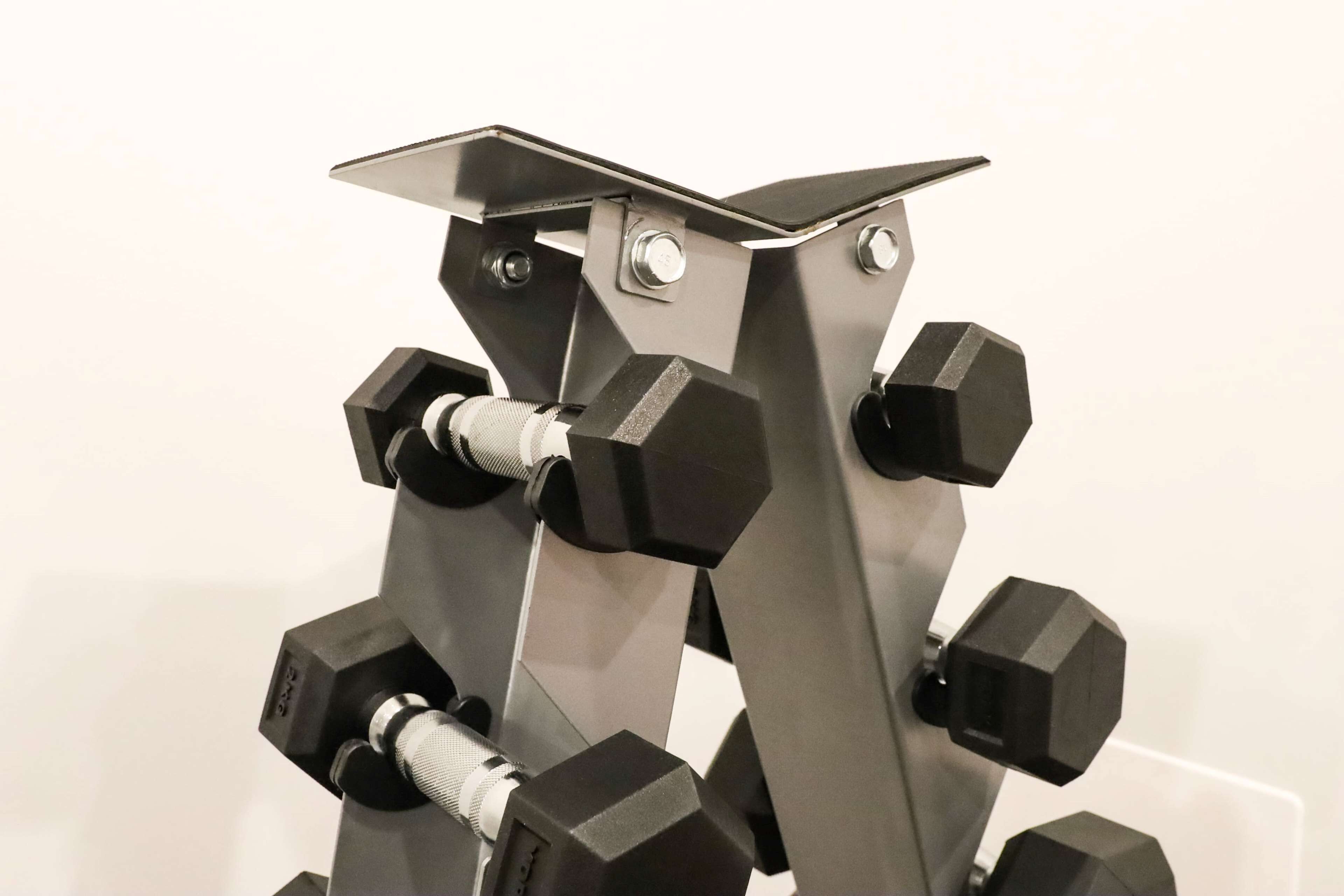 Una estructura metálica con varios contrapesos hexagonales negros adheridos.