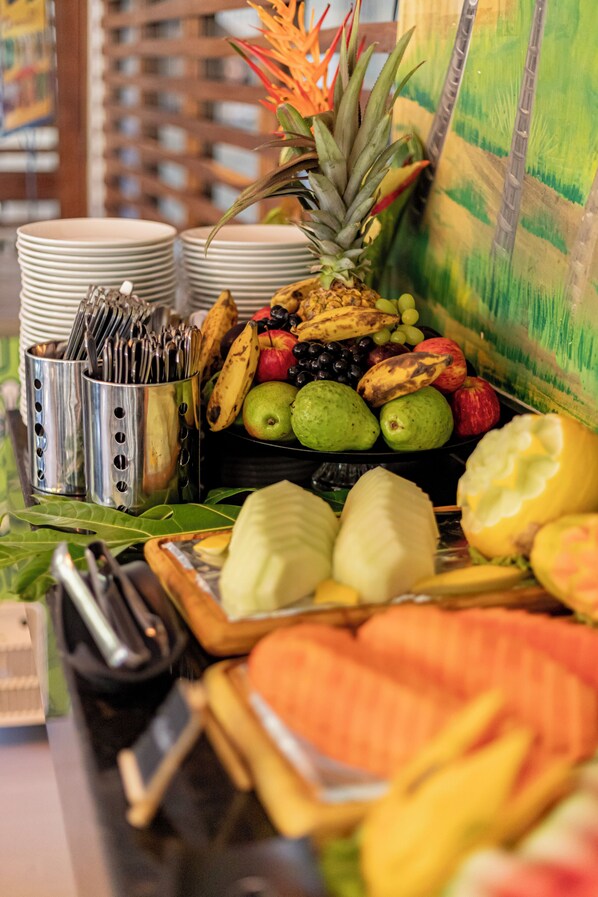 Una mesa de buffet con frutas, verduras y utensilios.