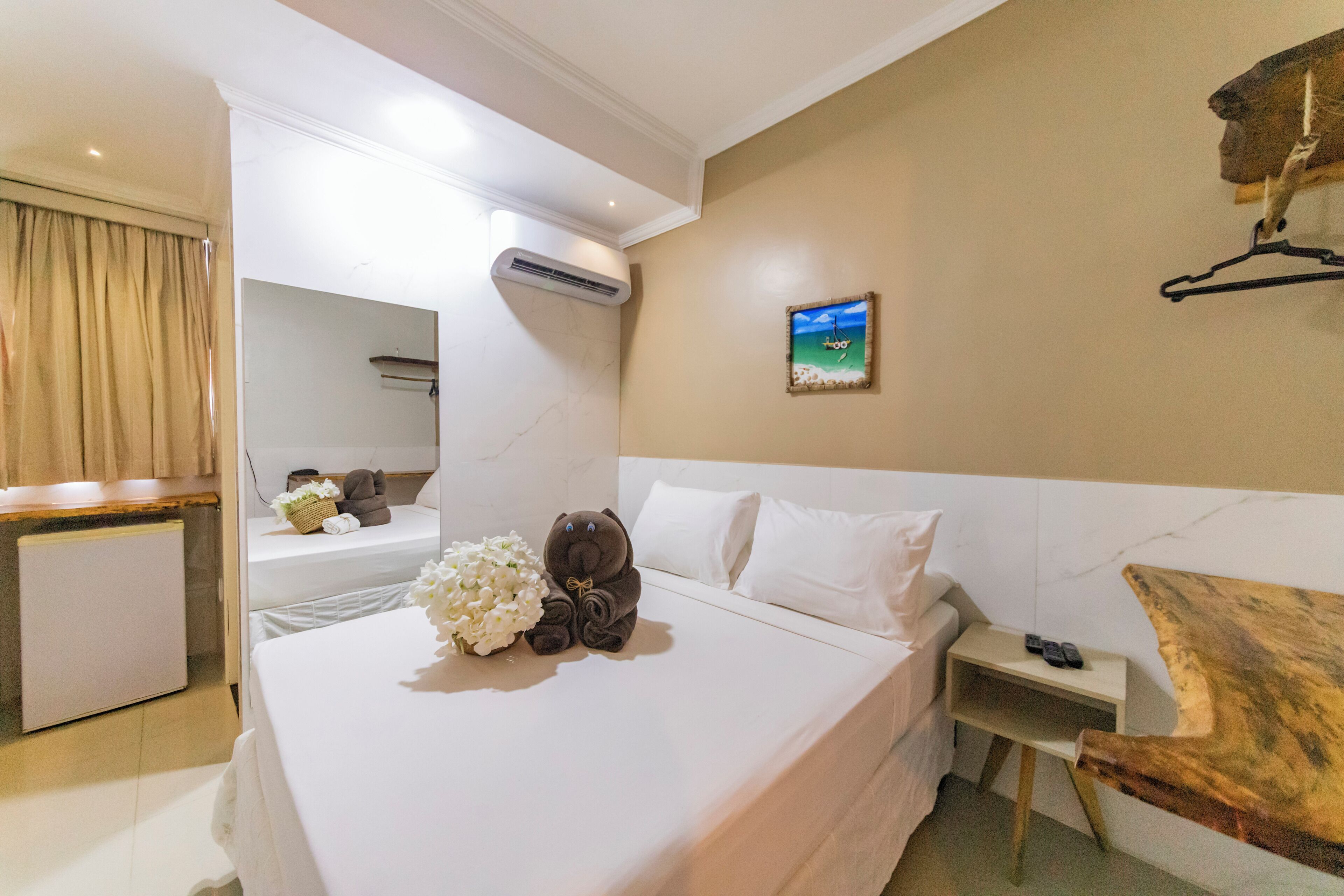 Une chambre d’hôtel avec un lit, une table de chevet et une petite table en bois.