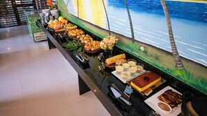 A buffet with various food items and a mural of a beach scene in the background. - Pousada Ponta de Mangue (Maragogi)