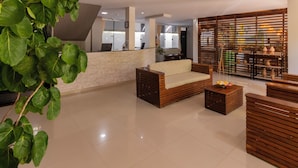 A spacious lobby with a reception desk, seating area, and a decorative wall. - Pousada Ponta de Mangue (Maragogi)