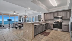 A modern kitchen with grey cabinets, stainless steel appliances, and a large island. - Beachfront,POB II #601 Parking Level,4 Bedroom, Immaculate, Great Views
 (Orange Beach)