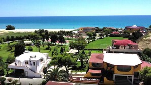 Una località balneare con diverse ville, una spiaggia e un campo da golf.