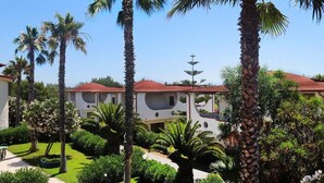 Un resort con diversi edifici, palme e giardini curati.