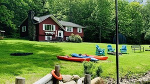 A lakeside cabin with kayaks and a paddle boat docked near the water. - Perfect Lake or Mountain Getaway Less Than 5 Minutes Away (Sunapee)