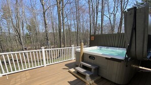 A hot tub on a wooden deck with a white railing, surrounded by trees. - Spacious Kennebunkport River property, family/pet friendly, 2 miles to beaches (Kennebunk)