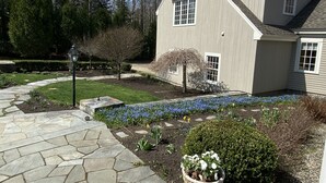A house with a stone pathway leading to the front door, surrounded by a well-maintained garden with flowers and shrubs. - Spacious Kennebunkport River property, family/pet friendly, 2 miles to beaches (Kennebunk)