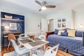 Cozy retreat with a central bed, ceiling fan, and artwork adorns the walls.