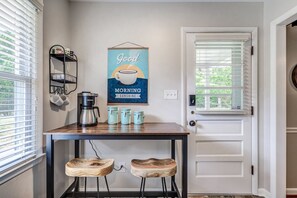 Enjoy a morning coffee at the kitchen table with a Keurig coffee maker and a coffee dispenser.