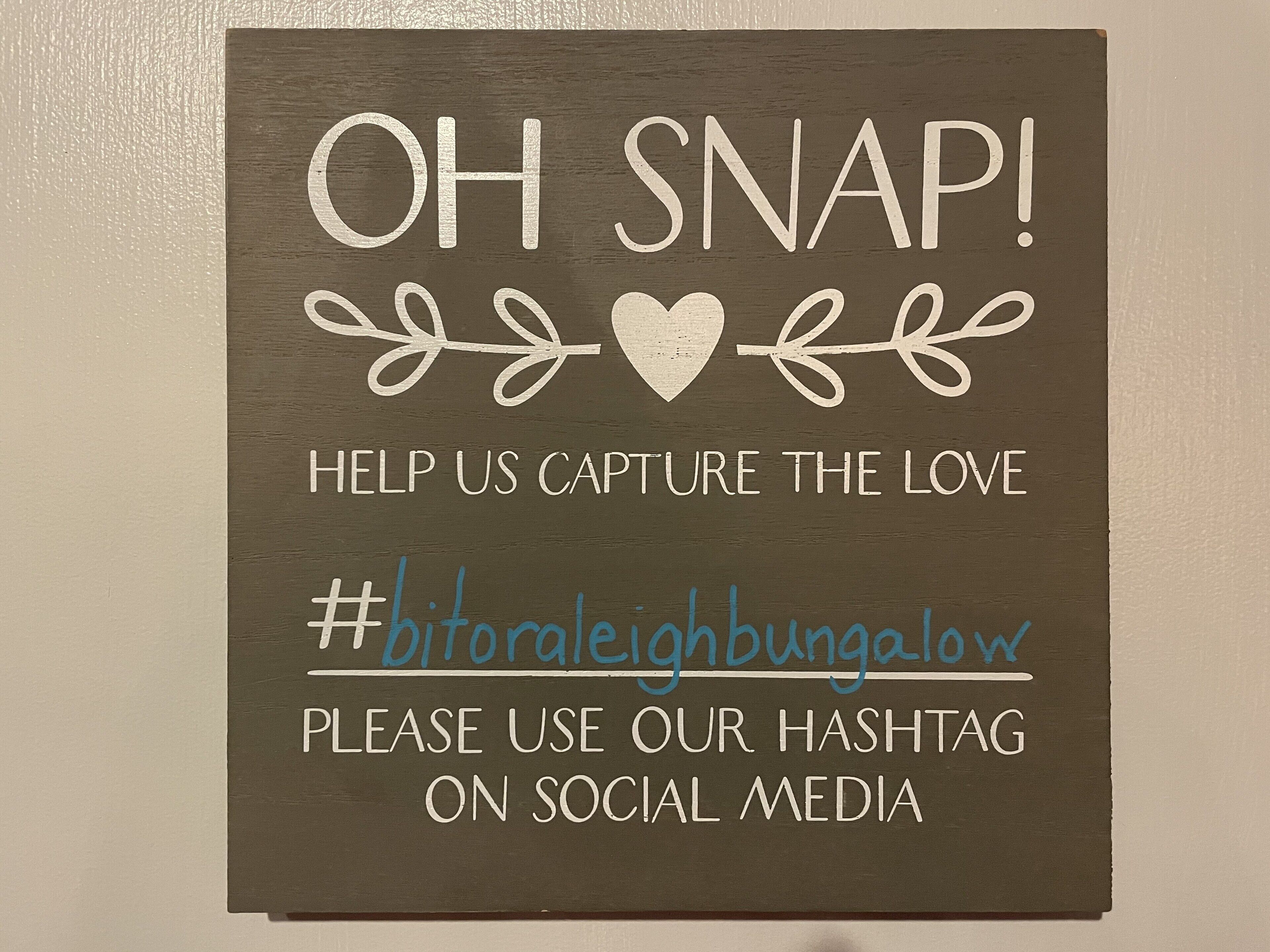 A sign with text and a hashtag for social media engagement.