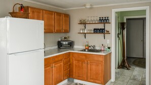 A kitchen with wooden cabinets, a white refrigerator, a toaster, and a sink.
