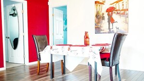A dining area with a table set for four, two chairs on each side, and a red door in the background. - Beautiful Paris in El Paso Home❤️ 3BR Near Ft Bliss (El Paso)