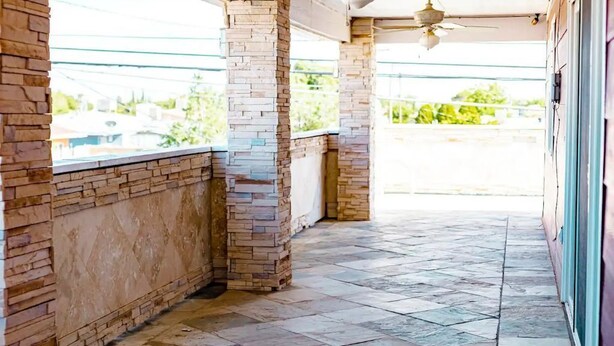 A covered outdoor area with stone columns and a tiled floor, leading to a building entrance. - Beautiful Paris in El Paso Home❤️ 3BR Near Ft Bliss (El Paso)