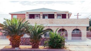 A two-story building with a stone facade, multiple windows, and a gated entrance. - Beautiful Paris in El Paso Home❤️ 3BR Near Ft Bliss (El Paso)