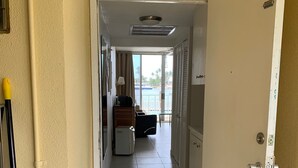 A hotel corridor with a view of a pool and a door leading to a room. - Paradise Found - No Better View on the Coast (Pompano Beach)