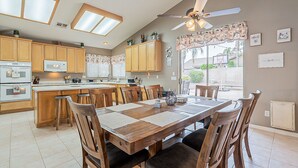 A spacious kitchen with wooden cabinets, a central island, and a dining area with a large table and chairs. - Very Large 5br, Arrowhead Ranch, Games, Quiet, Relaxing (Glendale)