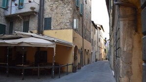 Un carrer estret amb terrasses i un restaurant.