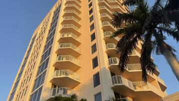 A high-rise building with multiple balconies and a clear sky.