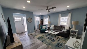 Un salón amplio con sofá, mesa de centro y mueble para televisión.