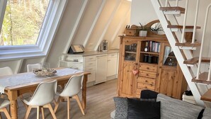 Un espace de vie moderne de style loft comprenant un coin repas, un canapé, un escalier et une cuisine.