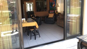 Ein Zimmer mit Esstisch, Stühlen, einer Couch, einem Deckenventilator, einer Uhr und einem Gemälde.
