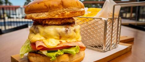 Una hamburguesa con papas fritas sobre una mesa de madera.