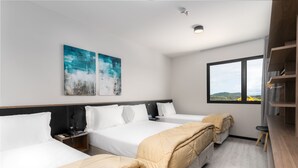 A hotel room with two beds, a desk, a chair, and a window with a view. - Solar Pedra da Ilha (Penha)