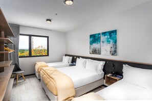 A modern hotel room with two beds, a desk, and a chair. There is a window with a view of a roller coaster. - Solar Pedra da Ilha (Penha)