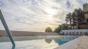 A clear swimming pool with a view of the sky and palm trees. - Spectacular Oceanfront Views ~ Olympic Sized Heated Oceanfront Pool (Saint Augustine)