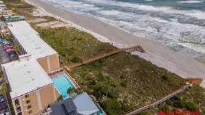 A coastal hotel with a beach view, a swimming pool, and a boardwalk leading to the beach. - Spectacular Oceanfront Views ~ Olympic Sized Heated Oceanfront Pool (Saint Augustine)