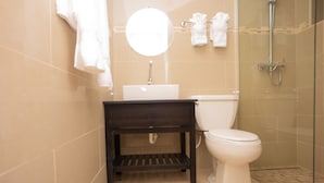 Un baño con inodoro, lavamanos y ducha.